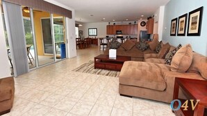 A spacious living area with a sofa, a coffee table, and a dining table in the background. - Ov2465 - Bella Vida Resort - 6 Bed 5.5 Baths Villa (Kissimmee)