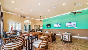 A spacious dining area with high ceilings, ceiling fans, and a green accent wall. - Ov2465 - Bella Vida Resort - 6 Bed 5.5 Baths Villa (Kissimmee)