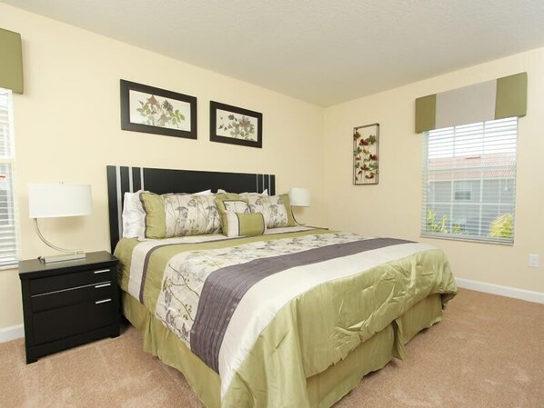 A bedroom with a bed, nightstands, and wall art.