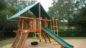A wooden play structure with a slide, climbing net, and swings. - Ov1584 - Glenbrook Resort - 4 Bed 3 Baths Villa (Clermont)