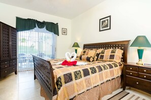 A neatly arranged bedroom with a bed, bedside tables, a wardrobe, and a view through a window with curtains. - Ovm1446 - Westridge - 4 Bed 3 Baths Villa (Davenport)