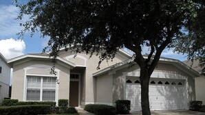 A residential house with a garage, a driveway, and a well-maintained lawn. - Ov2564 - Windsor Palms Resort - 4 Bed 2 Baths Townhome (Kissimmee)