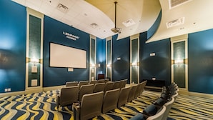 A conference room with rows of chairs, a large screen, and wall-mounted lighting. - Ov2558 - Champions Gate Resort - 5 Bed 4.5 Baths Villa (Davenport)