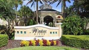 A sign for Windsor Hills Clubhouse with a landscaped garden in front.