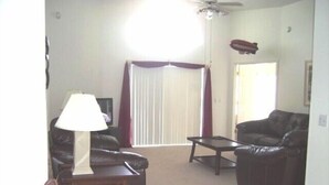 A living room with two leather sofas, a coffee table, a lamp, and a ceiling fan. - Ov1761 - Davenport Lakes - 4 Bed 2 Baths Villa (Davenport)