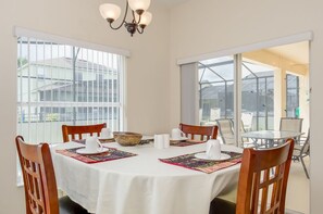A dining area with a round table set for four, surrounded by wooden chairs. - Ovm1887 - The Sanctuary at West Haven - 5 Bed 3 Baths Villa (Davenport)
