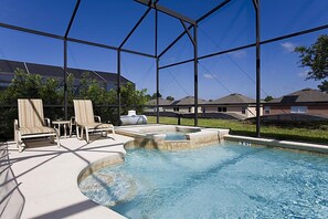 Piscina con lettini e vasca idromassaggio, circondata da un'area coperta con vista sulle case.