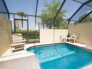 A swimming pool with a covered area, a chair, and a table. - Ov2138 - Windsor Hills Resort - 3 Bed 2.5 Baths Townhome (Kissimmee)