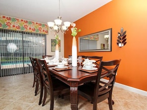A dining room with a wooden table set for six, surrounded by dark wooden chairs. - Ov2858 - Champions Gate Resort - 9 Bed 5 Baths Villa (Davenport)