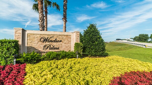 A landscaped entrance with a sign for 'Windsor Palms' and a view of a road in the background. - Ov2582 - Windsor Palms Resort - 5 Bed 3.5 Baths Villa (Kissimmee)