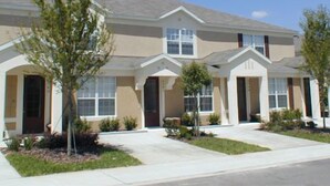 A two-story residential building with a symmetrical facade, multiple windows, and a central entrance.