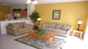 A living room with two sofas, a coffee table, a lamp, and a plant.