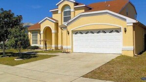 A two-story house with a garage, a driveway, and a well-maintained lawn. - Ov2186 - Lindfields - 5 Bed 3 Baths Villa (Kissimmee)