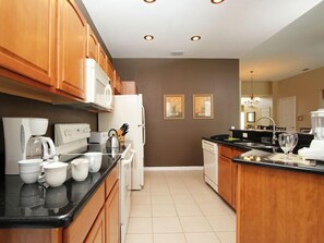 Fully equipped kitchen with a refrigerator, microwave, and coffee maker.