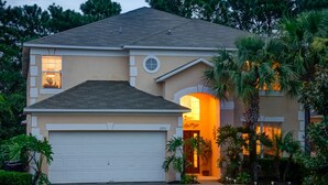 A two-story house with a garage, a circular window, and a well-lit entrance. - Ovm604 - Emerald Island - 6 Bed 5.5 Baths Villa (Kissimmee)
