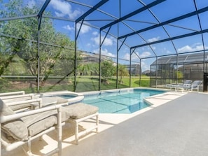A covered outdoor swimming pool with a clear view of the surrounding landscape, including trees and a distant building. - Ov535 - Emerald Island - 7 Bed 4 Baths Villa (Kissimmee)