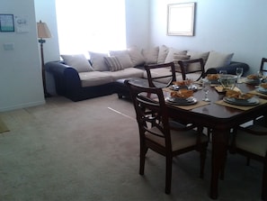 Enjoy meals in this dining area with a table set for four, surrounded by comfortable seating and a sofa.