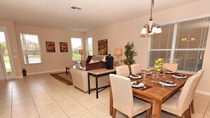 A spacious dining area with a wooden table set for six, surrounded by beige chairs. There is a sofa and a small table with a lamp in the background. - Ov2630 - Bella Vida Resort - 6 Bed 5.5 Baths Villa (Kissimmee)