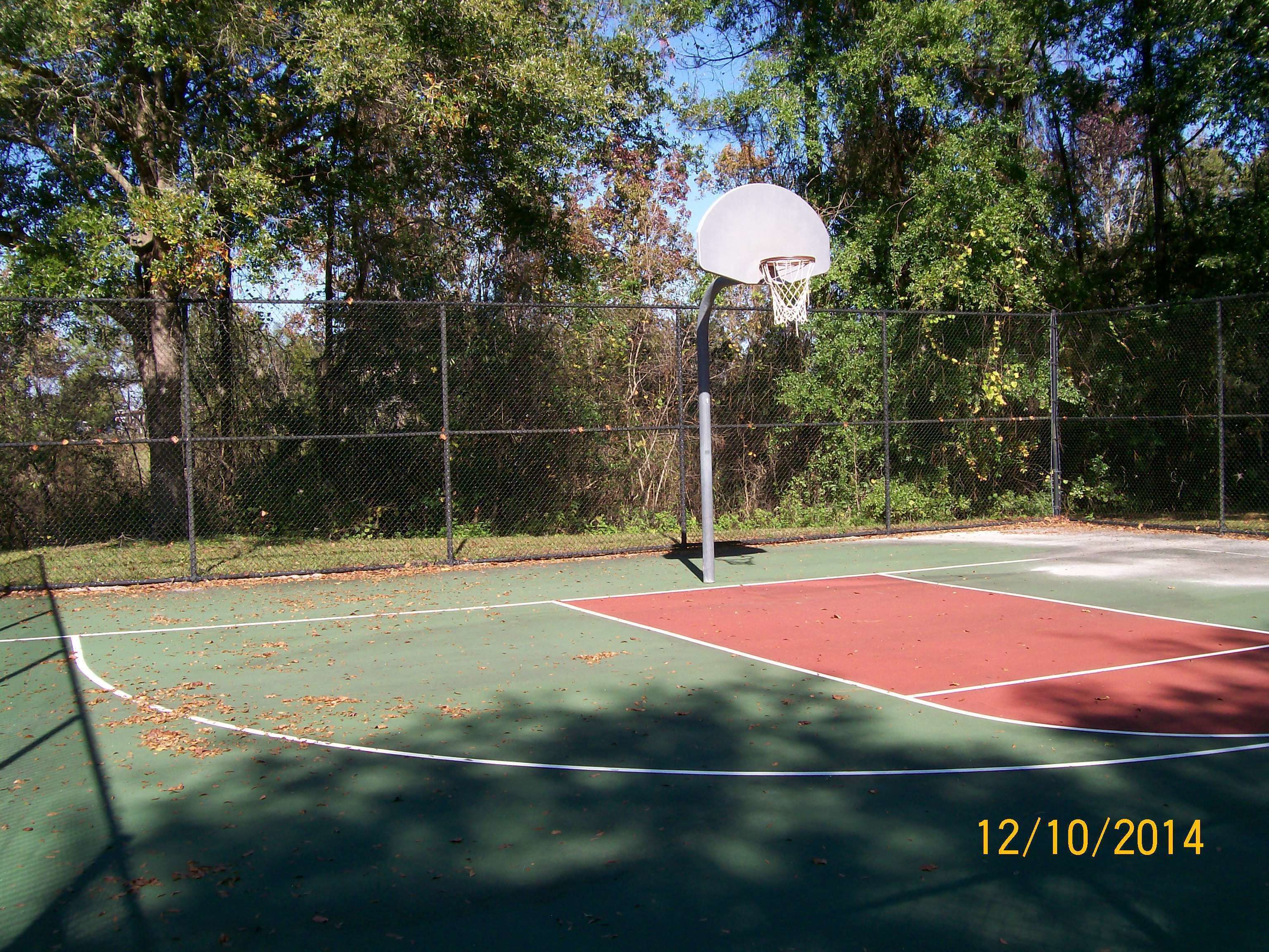 Ein Basketballplatz im Freien mit einem Drahtzaun, Bäumen und einem Stempel mit dem Datum 12.10.2014.