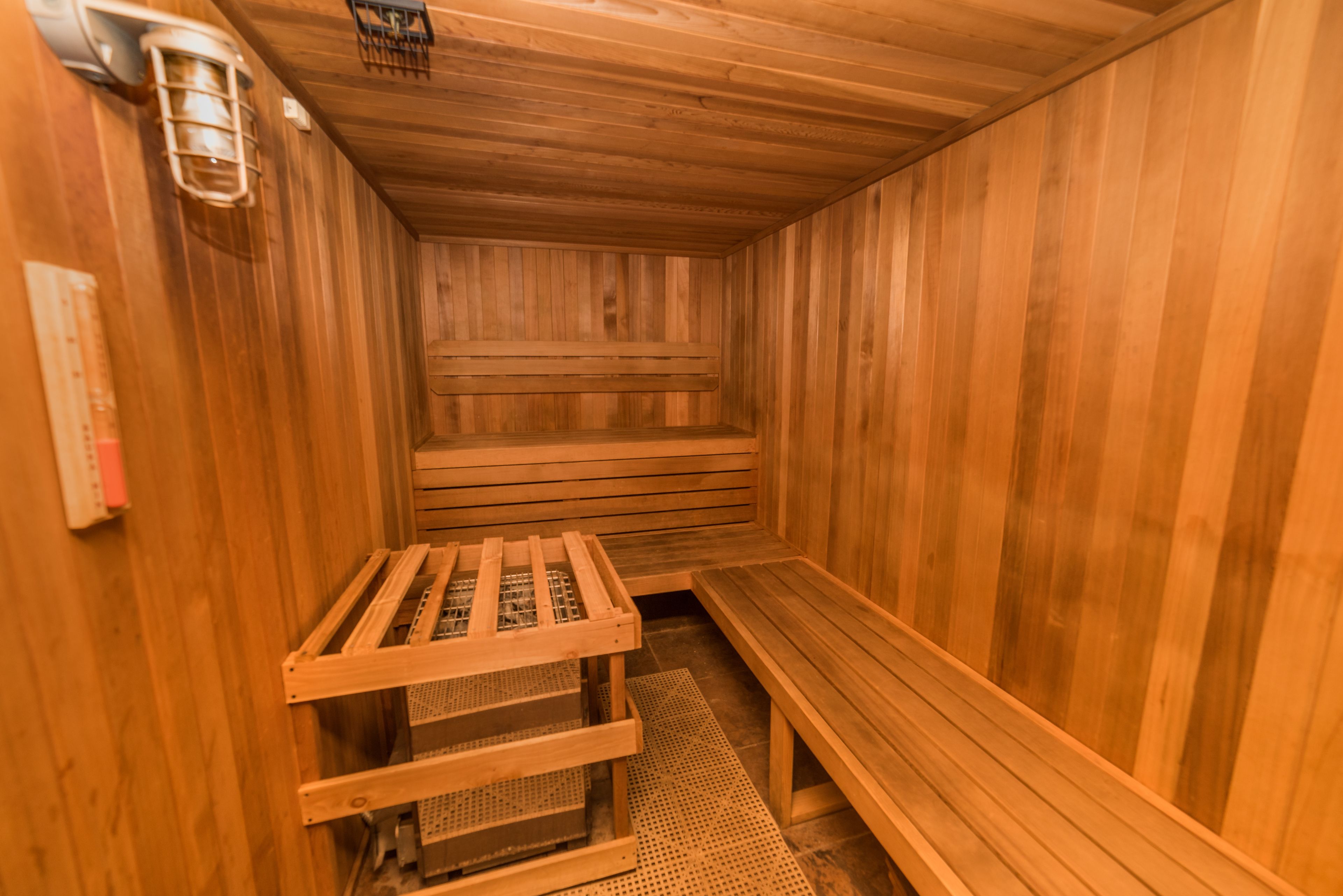 A wooden sauna with benches and a bench with a metal frame.
