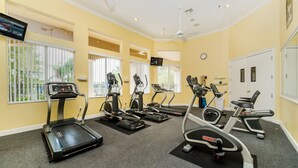 A gym with treadmills, elliptical machines, and a television screen. - Ovm1754 - Terra Verde Resort - 4 Bed 3 Baths Townhome (Kissimmee)