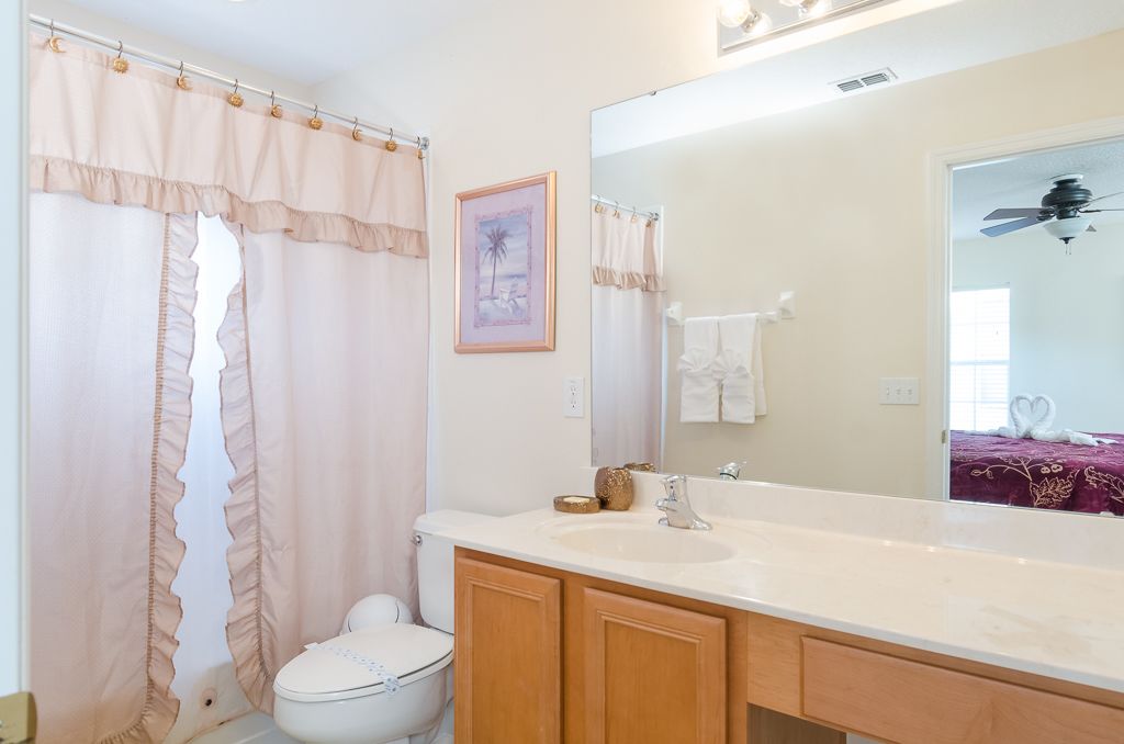 Une salle de bain avec des toilettes, un lavabo et un miroir.