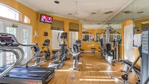A gym with cardio equipment, weight machines, and a television on the wall. - Ov474 - Emerald Island - 7 Bed 6 Baths Villa (Kissimmee)