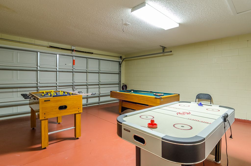Une pièce équipée d’un baby-foot, d’une table de billard et d’une table de ping-pong.