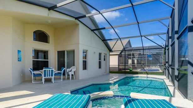 Ein Poolbereich mit Liegestühlen und einer überdachten Terrasse.