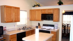A kitchen with wooden cabinets, a microwave, a stove, and a dishwasher. - Ov2672 - Lindfields - 4 Bed 3 Baths Villa (Kissimmee)