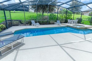 Ein überdachter Pool im Freien mit Liegestühlen und einem Tisch.