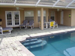 A swimming pool area with lounge chairs and a table, surrounded by a tiled deck. - Ov4069 - Vista Park - 5 Bed 4 Baths Villa (Davenport)