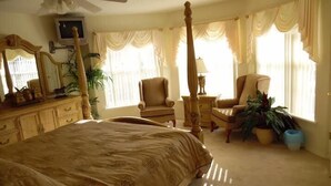 A bedroom with a four-poster bed, a ceiling fan, a television, and two chairs. - Ov4069 - Vista Park - 5 Bed 4 Baths Villa (Davenport)