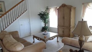 A living room with a sofa, a coffee table, a lamp, and a cabinet. - Ov4069 - Vista Park - 5 Bed 4 Baths Villa (Davenport)