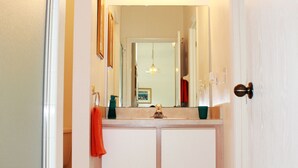 A bathroom with a white vanity, a mirror above the sink, and a light fixture above the mirror. - Ov3868 - Hampton Lakes - 5 Bed 3 Baths Townhome (Davenport)