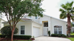 A two-story house with a garage, a front door, and a driveway. - Ov3868 - Hampton Lakes - 5 Bed 3 Baths Townhome (Davenport)