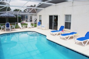 Ein Poolbereich mit Liegestühlen und einer überdachten Terrasse.