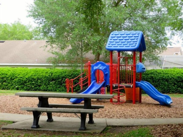 Ein Spielplatz mit einer Rutsche und einer roten und blauen Spielgerät.