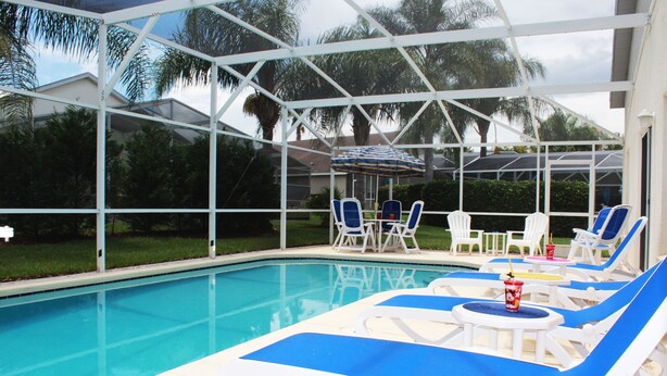 A pool area with lounge chairs and a covered seating area. - Ov3868 - Hampton Lakes - 5 Bed 3 Baths Townhome (Davenport)