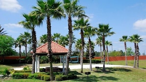 A gazebo surrounded by palm trees and a well-maintained lawn. - Ov3875 - Solana - 6 Bed 5 Baths Townhome (Davenport)