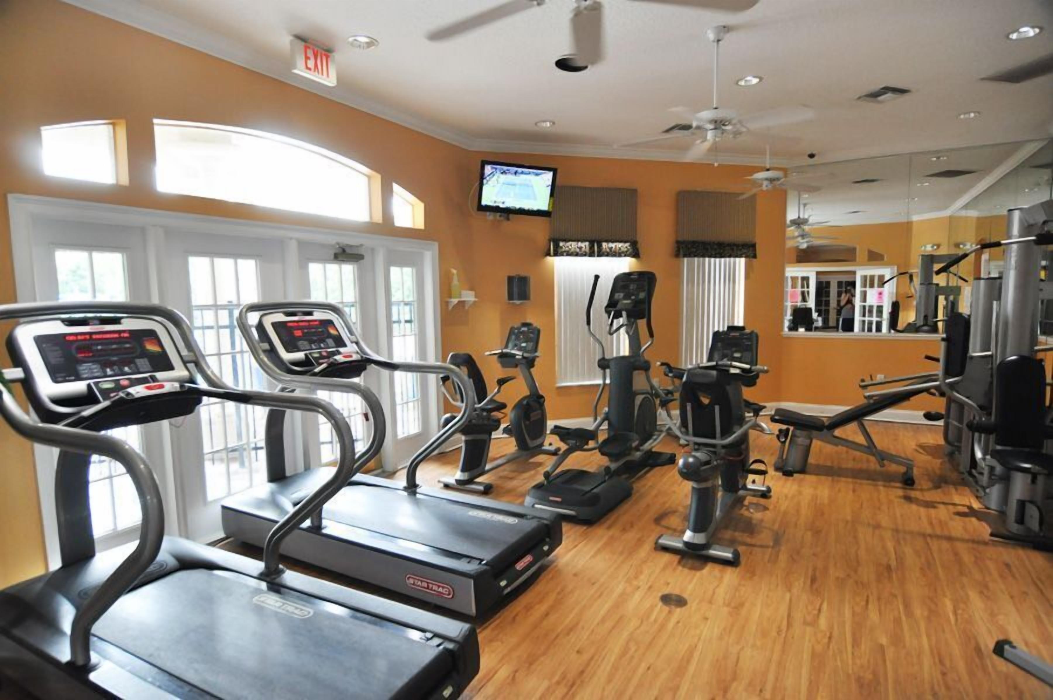 A gym with treadmills, elliptical machines, and weight equipment.