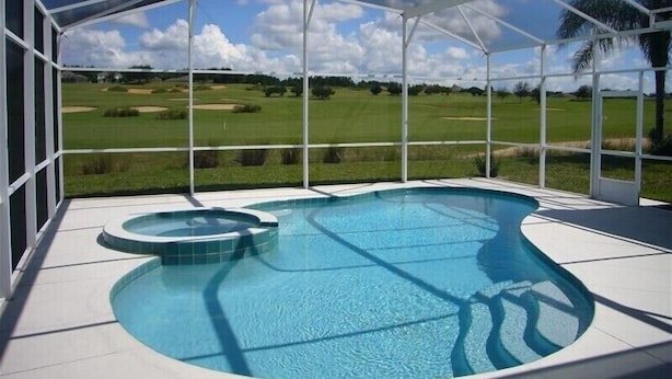 A covered swimming pool with a view of a golf course. - Ov4075 - Highlands Reserve - 4 Bed 3 Baths Villa (Davenport)