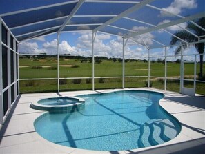 Una piscina techada con vista a un campo de golf.