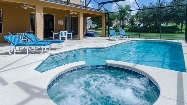Une piscine avec des chaises longues et un jacuzzi.