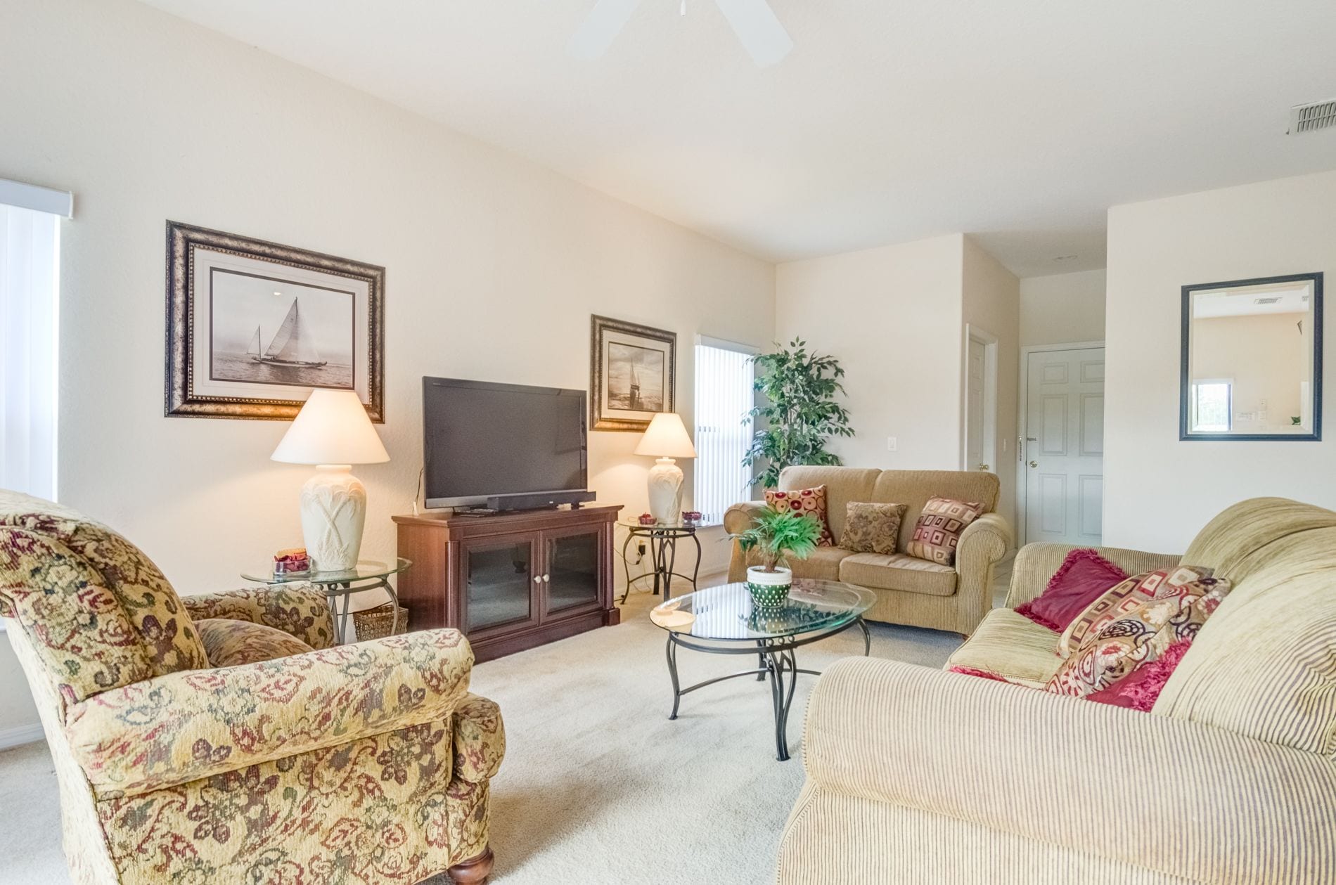 A living room with a television, two lamps, a coffee table, and two sofas.