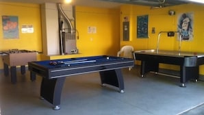 Ein Erholungsbereich mit Billardtisch, Kicker und Poolbillard.