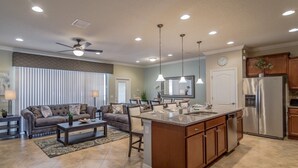 A modern kitchen with a central island, built-in appliances, and pendant lighting. - Ov4105 - Windsor At Westside - 4 Bed 3.5 Baths Townhome (Kissimmee)