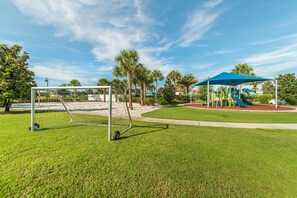 A well-maintained park with a soccer goal, playground equipment, and a clear blue sky. - Ov4105 - Windsor At Westside - 4 Bed 3.5 Baths Townhome (Kissimmee)