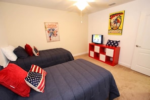 Un dormitorio con dos camas, un televisor y un mueble rojo para guardar objetos.
