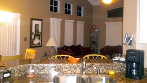 A kitchen with granite countertops, a coffee maker, and a ceiling fan. - Ov2568 - Emerald Island - 3 Bed 2.5 Baths Townhome (Kissimmee)